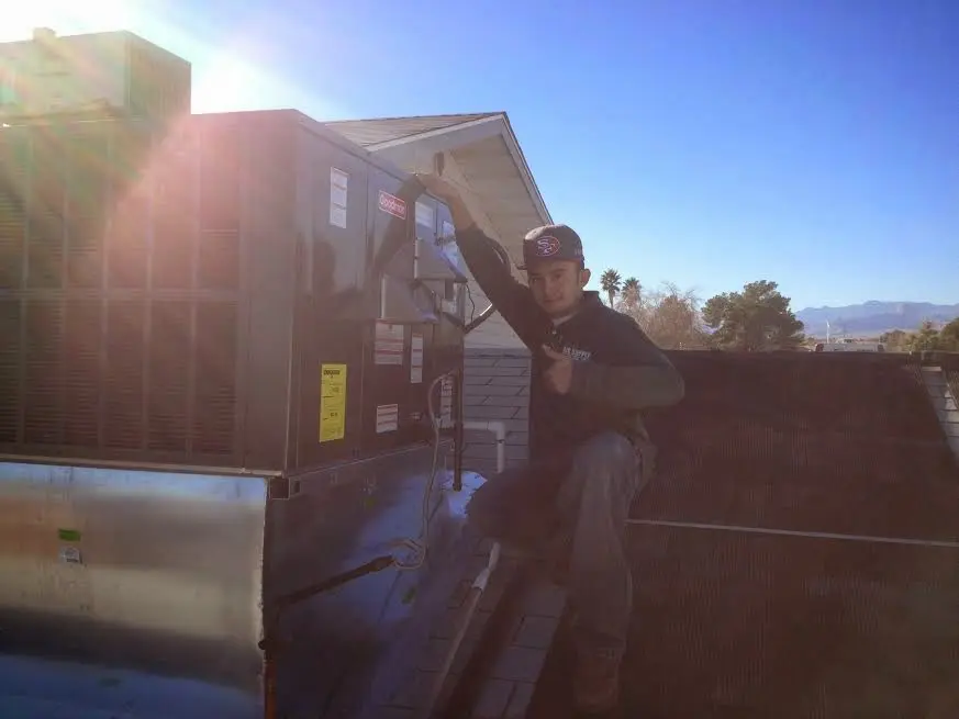 HVAC technician performing Boiler Repair on a rooftop unit in Rumson